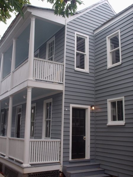 Twin stacked side porches with paneled rear entry door in the finished view.