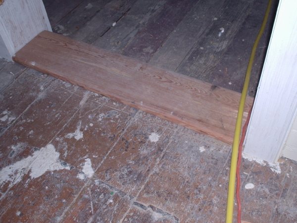 A new heart-pine board scarfed in beside the original 19th-century flooring.