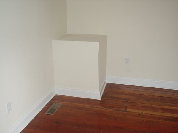 Finished chimney chase, painted, with refinished heart-pine and air return.