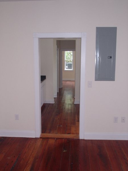 Final interior view through the doorway, with the new electrical panel set discreetly into the back wall.